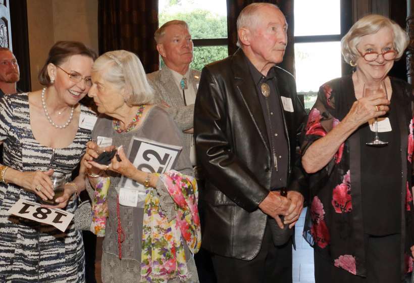 From left, Nedra Matteucci, Marian Ward, auction item donor Tom Harper (background), and John and Carol Carpenter assemble for the 2017 live auction.